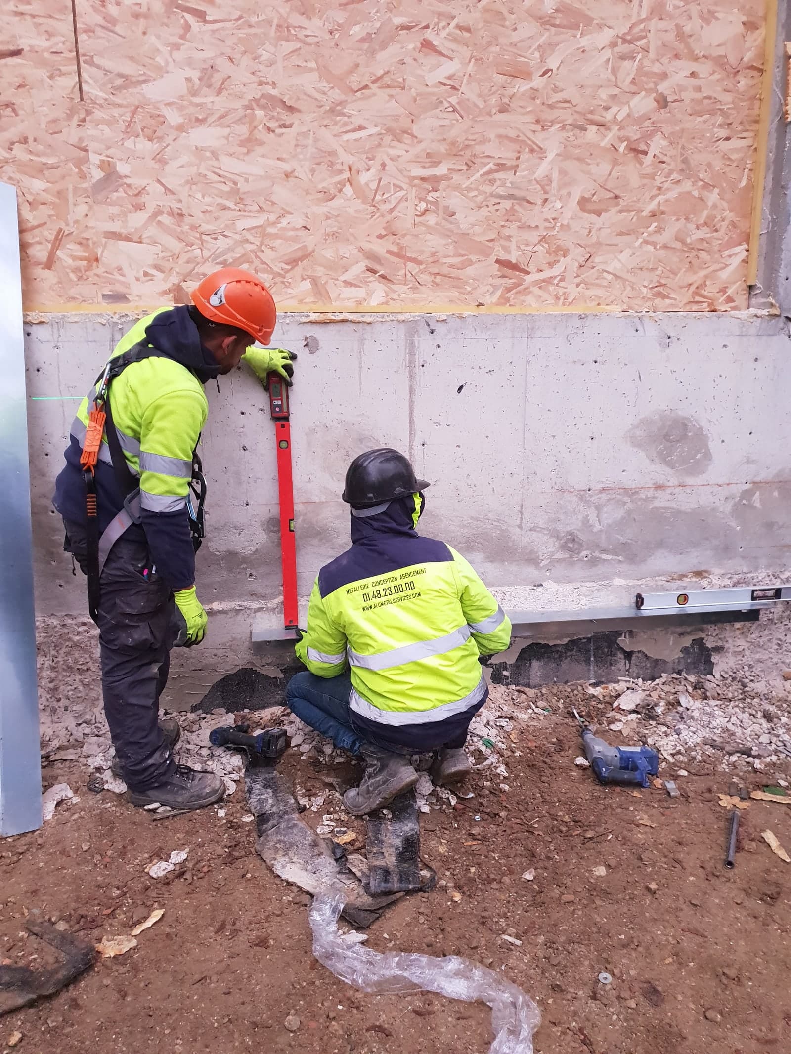 Duo de compagnons IEF prenant un niveau de précision sur chantier