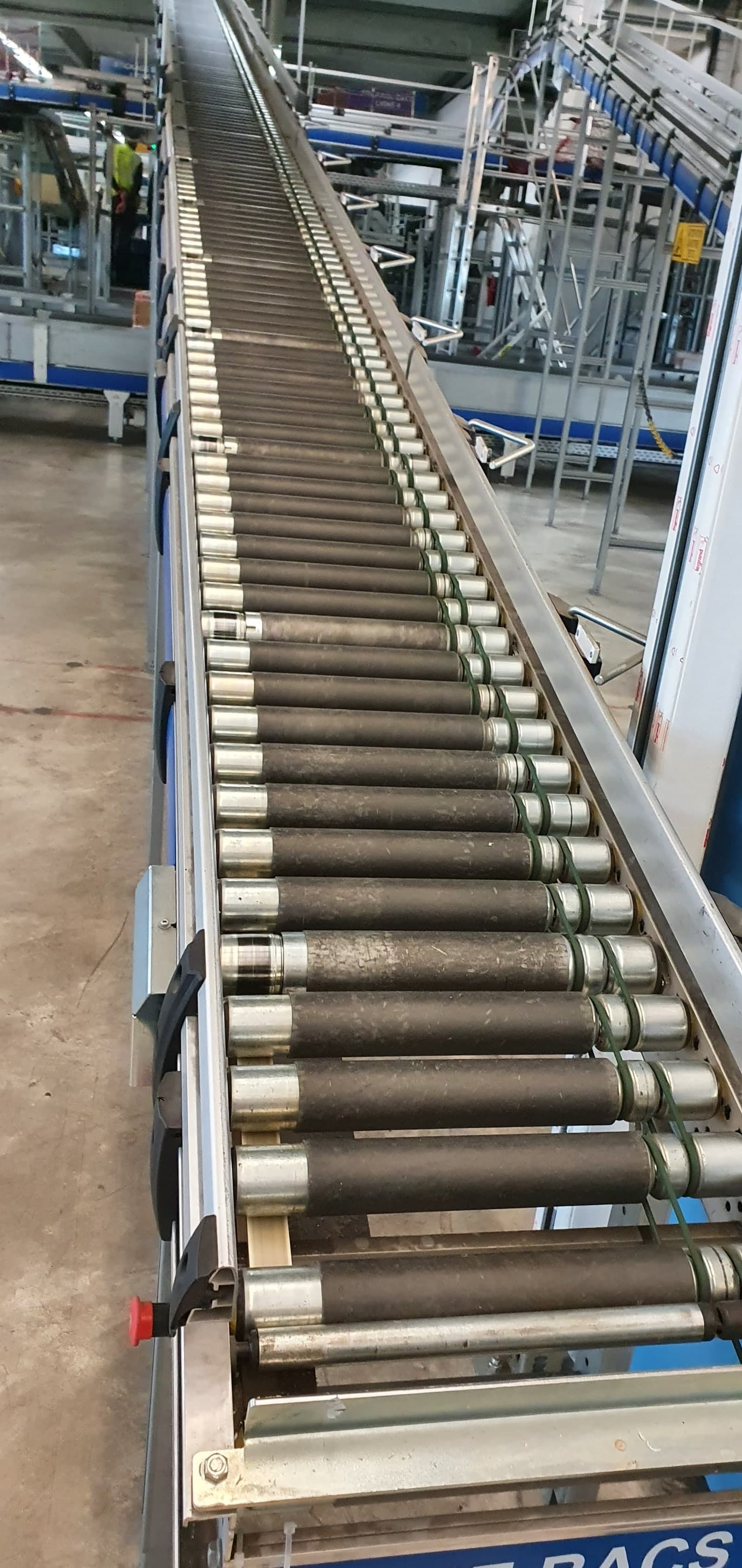 Convoyeur à rouleaux intégré dans structure métallique inclinée